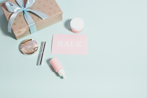 Ein Geschenkpaket, Muster von Kosmetikprodukten und ein Rabattgutschein als Beispiel für Geschenke, die in die E-Commerce Verpackung eingefügt werden können 