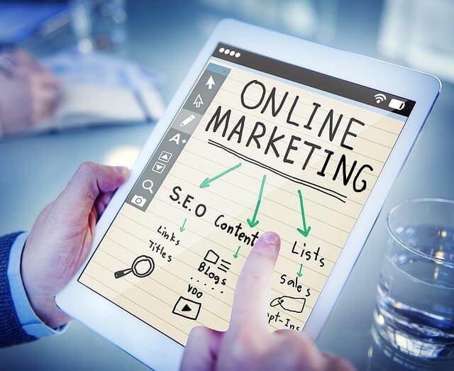 una persona scrive su un tablet un piano di strategia di marketing online